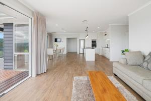 a living room and kitchen with a couch and a table at A million city views in Rotorua