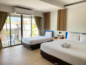 a hotel room with two beds and a balcony at Armoni Patong Beach Hotel in Patong Beach +168 photos