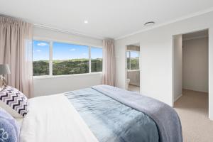 a bedroom with a bed and a large window at A million city views in Rotorua