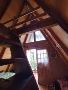Cette chambre mansardée dispose d'une échelle et d'une fenêtre. dans l'établissement Chalé na Serra Campo Alegre, à Campo Alegre