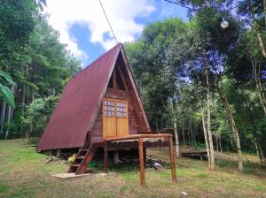 une petite maison au toit rouge dans une forêt dans l'établissement Chalé na Serra Campo Alegre, à Campo Alegre