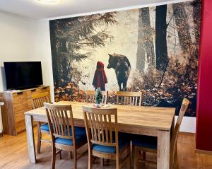 een eetkamer met een tafel en een schilderij aan de muur bij Fewo Unterm Stein - Rotkäppchen - 3 Schlafzimmer in Alheim