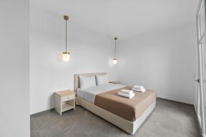 ein weißes Schlafzimmer mit einem Bett und einem Nachttisch in der Unterkunft Seahorse Villa in Makrotándalon + 12 Fotos