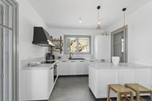 eine weiße Küche mit weißen Schränken und einem Fenster in der Unterkunft Seahorse Villa in Makrotándalon