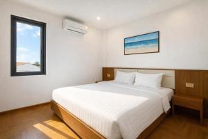 una camera da letto con un letto bianco e una finestra di Luxury 88 Hotel a Phủ Lý