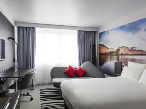 a hotel room with a bed and a desk at Novotel Edinburgh Centre in Edinburgh