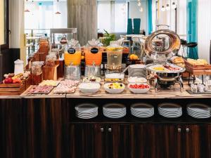 a buffet line with food and drinks on a table at Mercure Roma Piazza Bologna in Rome