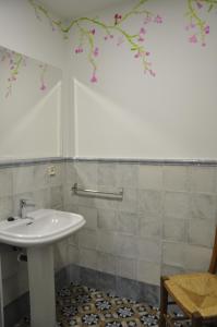 a bathroom with a sink and a chair at Casa de las Remigias in Estepona
