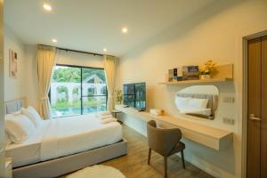 een slaapkamer met een bed, een spiegel en een stoel bij HighView PoolVilla at Khaoyai in Ban Bung Toei +153 foto's