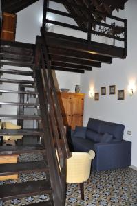 a living room with a blue couch and stairs at Casa de las Remigias in Estepona