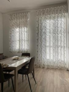 een eetkamer met een tafel en stoelen en een raam bij Salinelle Home in Paterno +11 foto's