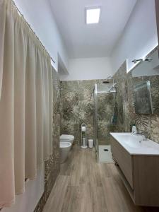 een badkamer met een wastafel, een toilet en een douche bij Salinelle Home in Paterno