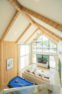 een woonkamer met een bank en een pooltafel bij HighView PoolVilla at Khaoyai in Ban Bung Toei