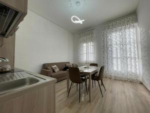 a kitchen and living room with a table and a couch at Salinelle Home in Paterno