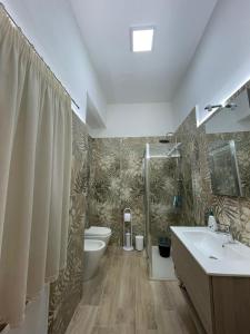 een badkamer met een wastafel, een toilet en een douche bij Salinelle Home in Paterno +11 foto's