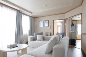 een woonkamer met een witte bank en een tafel bij Niseko Homey Home in Kutchan +69 foto's