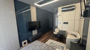 a small living room with a television and a couch at Premium Smart Studio with River View in Tbilisi City