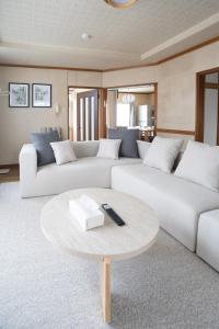 een woonkamer met twee witte banken en een tafel bij Niseko Homey Home in Kutchan