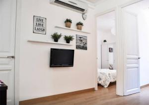 a living room with a tv on a wall at bcn4days 24/7 Apartments in Hospitalet de Llobregat