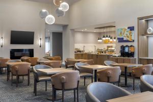 a restaurant with tables and chairs and a counter at Homewood Suites by Hilton Toronto-Ajax in Ajax