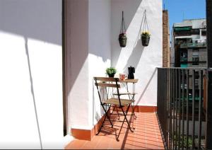 a balcony with a table and plants on a wall at bcn4days 24/7 Apartments in Hospitalet de Llobregat