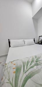 een bed in een witte kamer met een deken erop bij Everest Lounge in Abu Dhabi