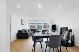 een woonkamer met een tafel, stoelen en een bank bij Hivent Ferienwohnungen in Bad Dürrheim