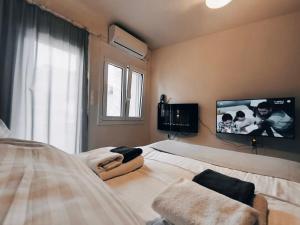 a bedroom with a bed with a tv on the wall at peramalux in Ioannina +3 photos