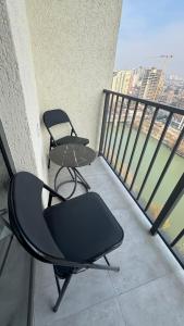 a balcony with two chairs and a table on it at Premium Smart Studio with River View in Tbilisi City