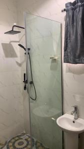 ein Badezimmer mit Glasdusche und Waschbecken in der Unterkunft Royal Nest Apartments in Lekki