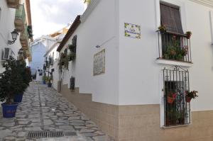 a cobblestone street in a town with white buildings at Casa de las Remigias in Estepona