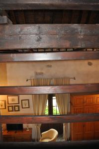 a room with a wooden ceiling with curtains and a chair at Casa de las Remigias in Estepona