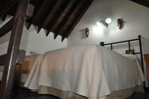 a bedroom with a bed with a white blanket on it at Casa de las Remigias in Estepona