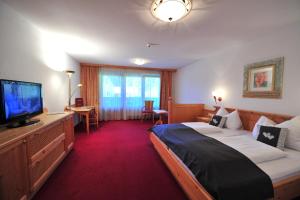 A bed or beds in a room at Hotel Alpenpanorama