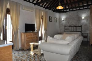 a living room with a white couch and a television at Casa de las Remigias in Estepona
