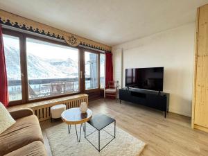 ein Wohnzimmer mit Sofa und Fernseher in der Unterkunft BEC452- Superbe 2 pièces, vue Lac - Tignes in Tignes