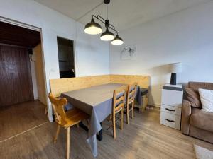 ein Esszimmer und ein Wohnzimmer mit Tisch und Stühlen in der Unterkunft BEC452- Superbe 2 pièces, vue Lac - Tignes in Tignes