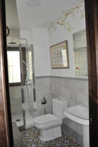 uma casa de banho com um WC, um chuveiro e um lavatório. em Casa de las Remigias em Estepona