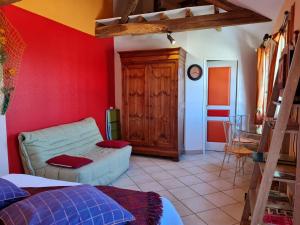 ein Wohnzimmer mit einem Sofa und einer roten Wand in der Unterkunft Chambre "La Volière", Champliveau in Bonnée