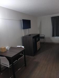 a room with a desk and a table and chairs at Bridgeview Inn Chicago Area in Bridgeview