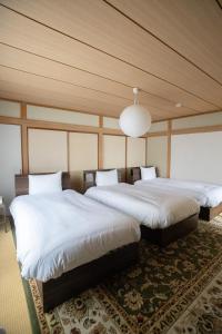 een rij van drie bedden in een kamer bij Niseko Homey Home in Kutchan