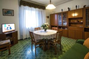 un salon avec une table avec des chaises et une télévision dans l'établissement Casa nella campagna Toscana, à Lazzeretto