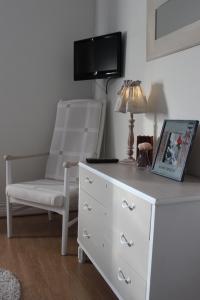 a bedroom with a white dresser and a chair at Skivarps Gästgivaregård in Skivarp