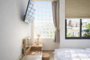 ein Schlafzimmer mit einem Bett und einem großen Fenster in der Unterkunft Adory Homestay Huế in Hue