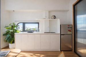 eine weiße Küche mit Spüle und Kühlschrank in der Unterkunft Adory Homestay Huế in Hue