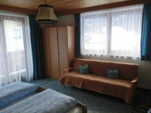 a hotel room with a couch and windows at Haus Pranger in Gschnitz