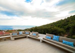 een patio met banken en uitzicht op de oceaan bij Villa Dolihi in Agios Kirykos