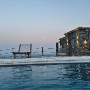 een huis met een zwembad en een bankje naast een gebouw bij Villa Dolihi in Agios Kirykos