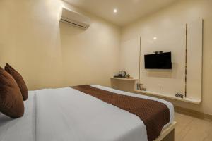 ein Schlafzimmer mit Bett und Flachbildfernseher in der Unterkunft Hotel Global Inn in Amritsar