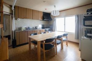 een keuken met een houten tafel en stoelen in een kamer bij Niseko Homey Home in Kutchan